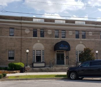 A Car Parked In Front Of A Brick Building