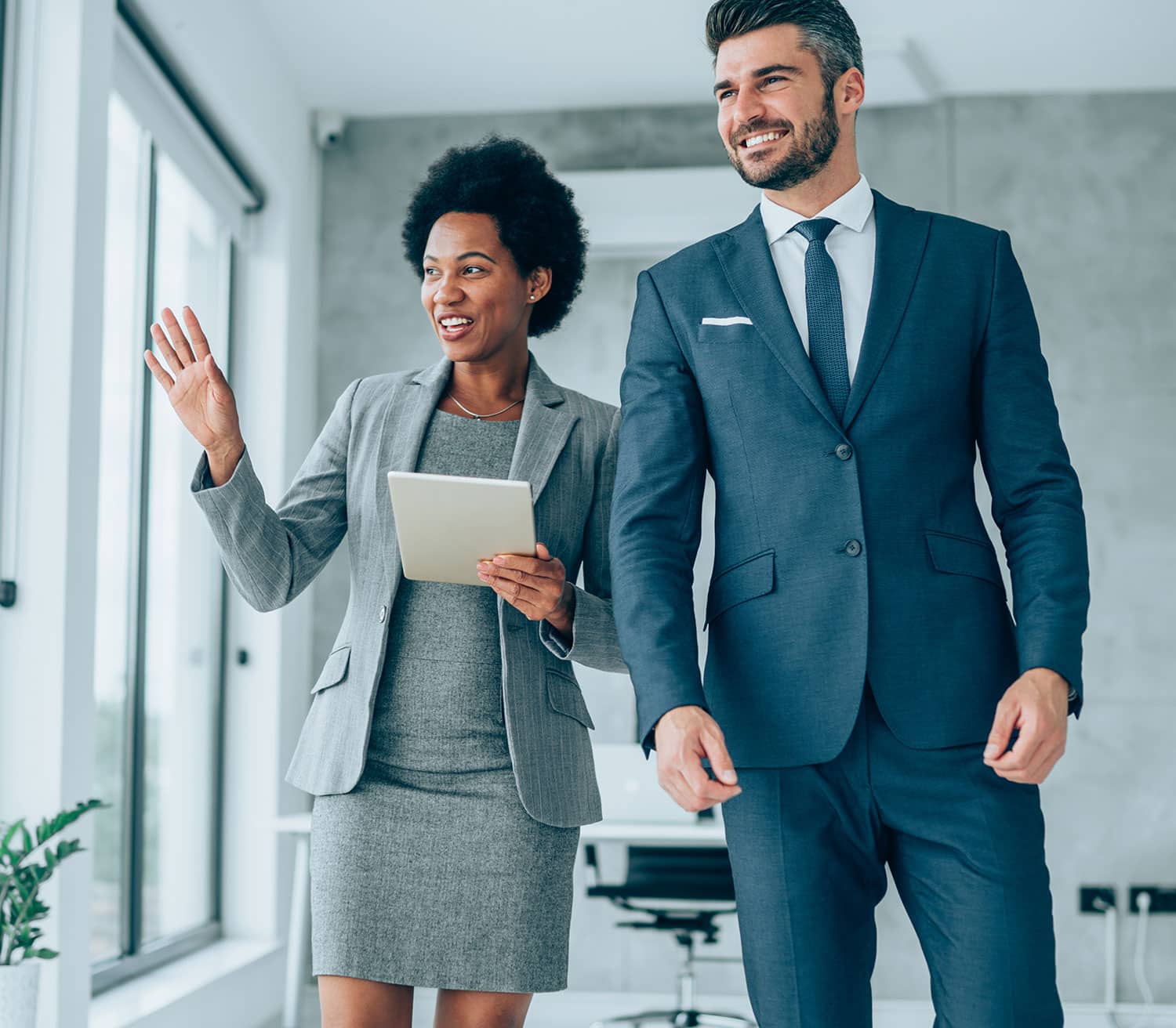 a man wearing a suit and tie standing next to a woman