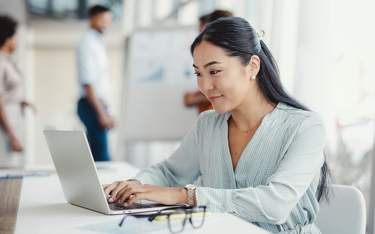 a person sitting at a table using a laptop computer