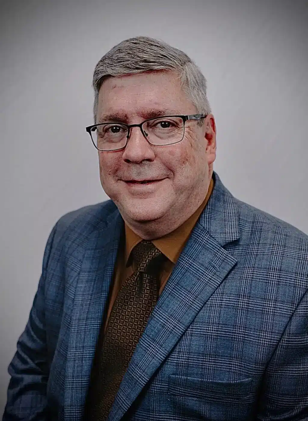 a man wearing glasses and looking at the camera