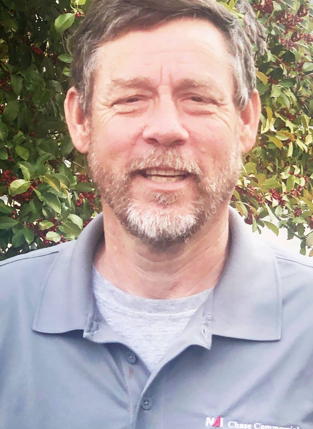 a man wearing glasses and smiling at the camera